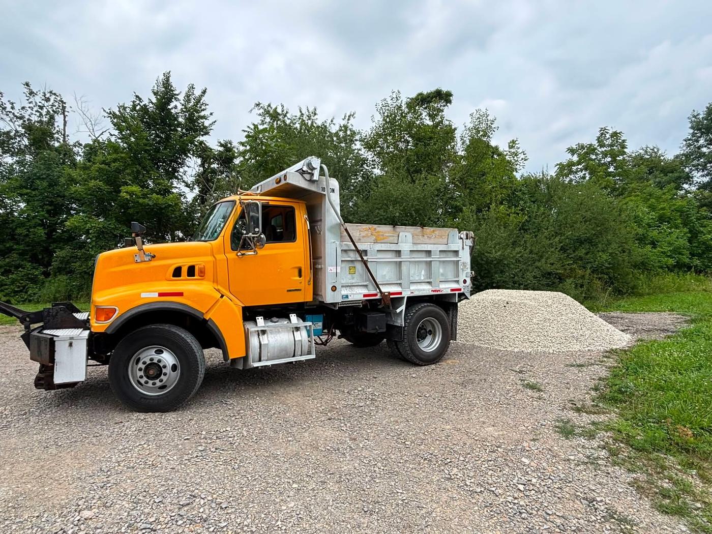 Funk Excavating dump truck parked next to a delivered pile of gravel